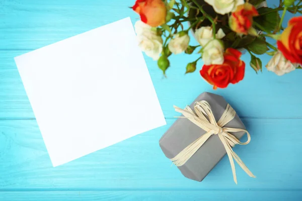 Rose, foglio di carta e scatola regalo su sfondo di legno — Foto Stock