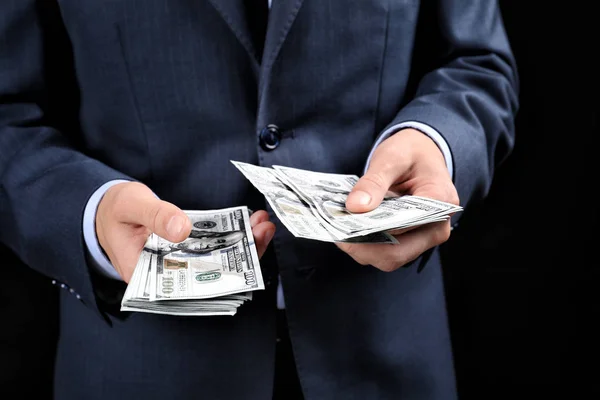 Zakenman met geld op donkere achtergrond. Corruptie concept — Stockfoto