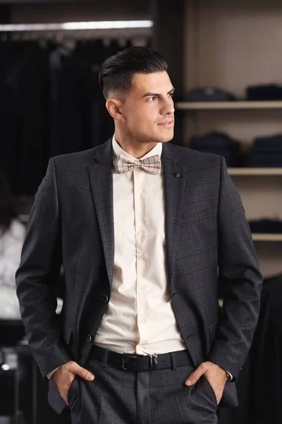 Handsome young man wearing suit in shop — Stock Photo, Image