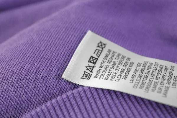 Oblečení značky s pokyny k údržbě, closeup — Stock fotografie