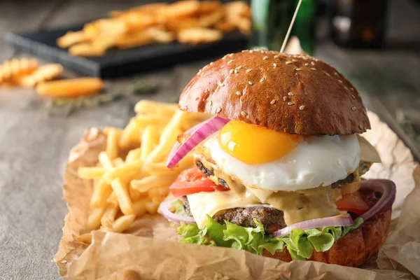 Вкусный бургер с яичницей на столе, крупным планом — стоковое фото