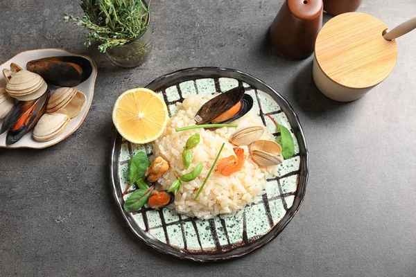 Placa con delicioso risotto de mariscos en la mesa — Foto de Stock