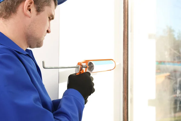 Construction worker repairing window in house — Stock Photo, Image