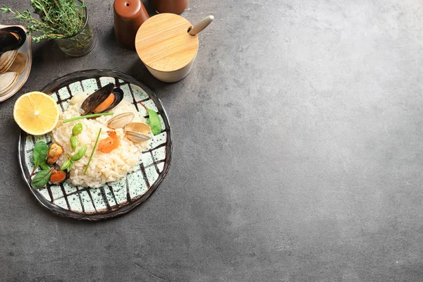 Placa con delicioso risotto de mariscos en la mesa — Foto de Stock