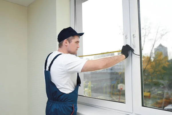 Trabalhador da construção reparando janela em casa — Fotografia de Stock