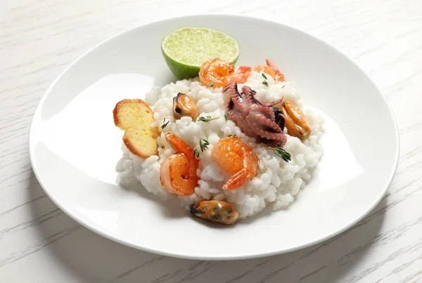 Plaat met smakelijke seafood risotto op tafel — Stockfoto