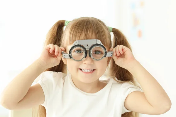 Schattig klein meisje met trial frame in de oogarts kantoor — Stockfoto