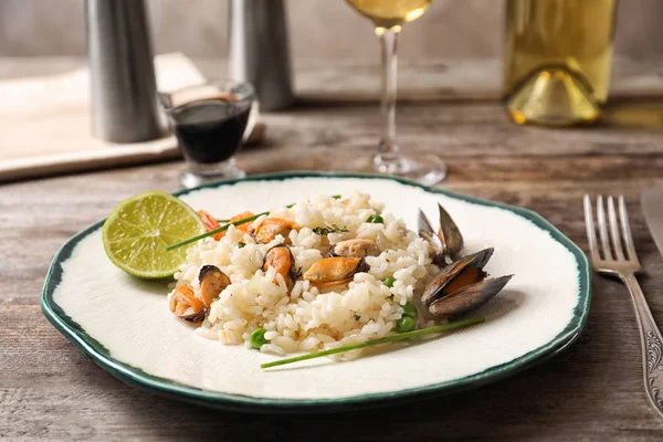 Assiette avec délicieux risotto de fruits de mer sur table en bois — Photo