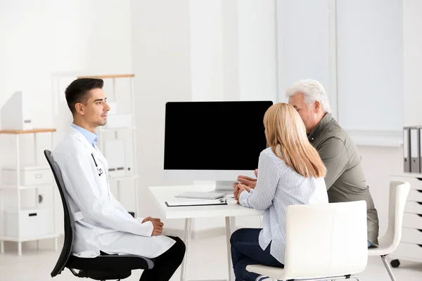 Manliga läkare samråd med ledande par i klinik — Stockfoto