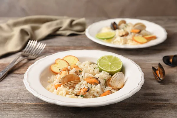 Plaat met heerlijke zeevruchten risotto op houten tafel — Stockfoto