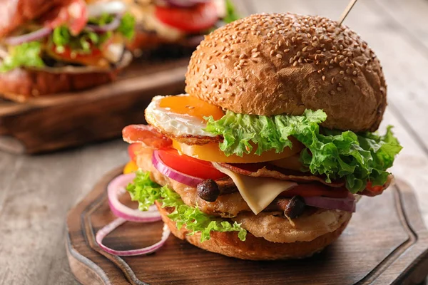 Tasty burger with fried egg on table — Stock Photo, Image