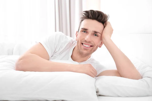 Młody człowiek leżący na białą poduszkę w domu — Zdjęcie stockowe