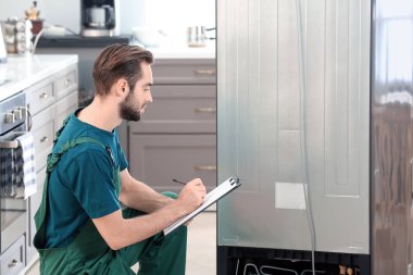 Kapalı buzdolabı tamiri sırasında erkek teknisyen