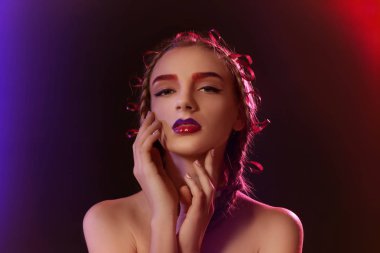 Koyu arka plan üzerine boyalı kaşlar olan kadın