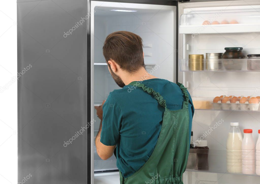 Male technician repairing refrigerator