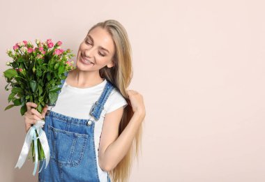 Renkli arka planda gül buketi olan güzel bir kadın.