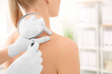 Onkoloji kliniğinde büyüteç ile muayene Bayan hasta. Kanseri Bilinçlendirme