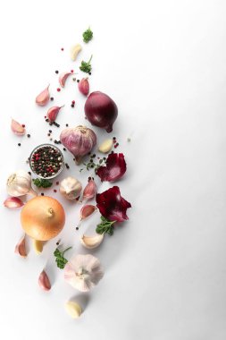 Taze sarımsak, soğan ve biber taneleri beyaz arka planda, üstten görünüm