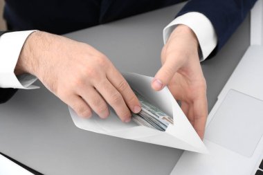 Businessman with bribe at table, closeup clipart