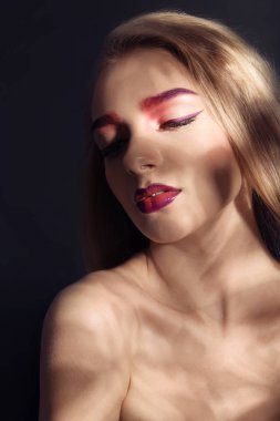 Siyah arka plan üzerine boyalı kaşlar olan kadın