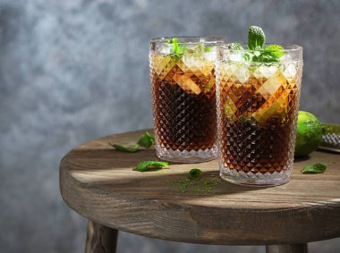 Cuba Libre ahşap masaya kokteyl iki bardak