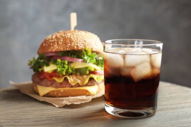 Kadeh tabloda lezzetli hamburger ile soğuk kola
