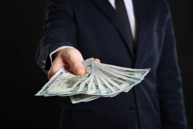Rüşvet siyah arka planda tutan işadamı