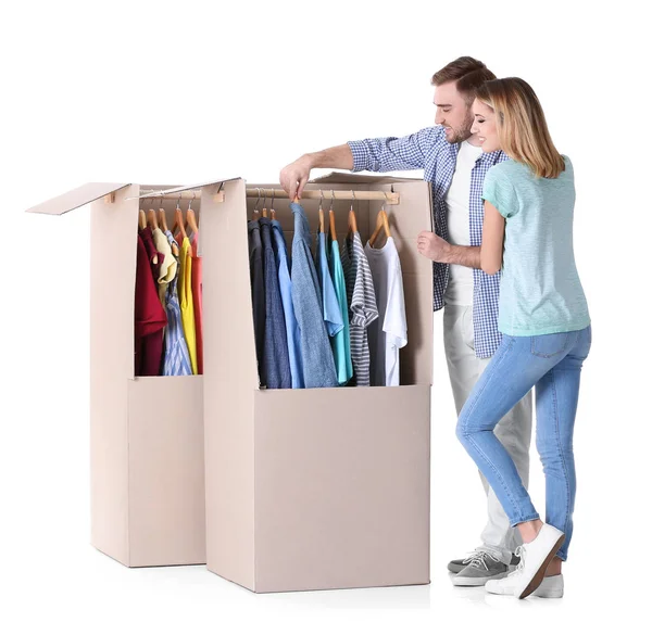 Young couple near wardrobe boxes on white background — Stock Photo, Image