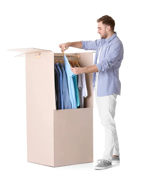 Fiatal férfi közelében szekrény doboz fehér háttér — Stock Fotó