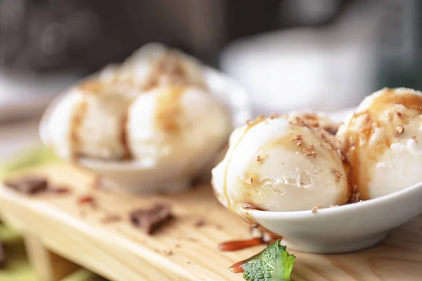 美味香草冰淇淋球与焦糖顶在碗上的板 — 图库照片