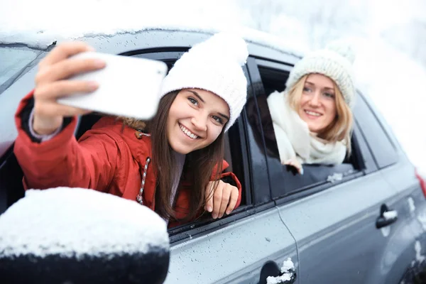 Kobiece turystów biorąc selfie, siedząc w samochodzie — Zdjęcie stockowe