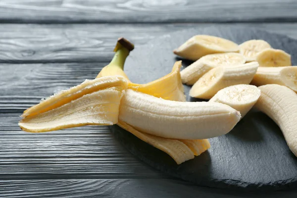 Assiette Ardoise Avec Bananes Mûres Sur Fond Bois — Photo