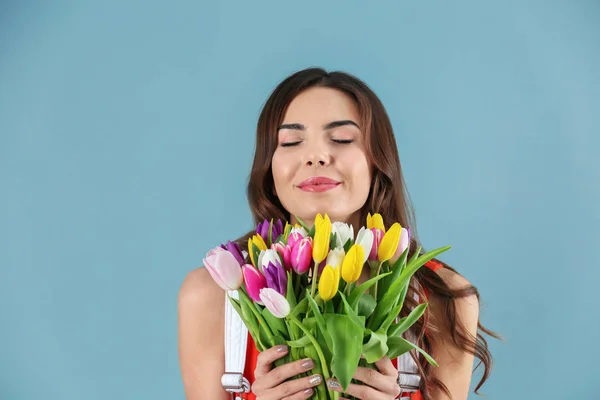 色の背景上チューリップの花束を持った美しい女性 — ストック写真