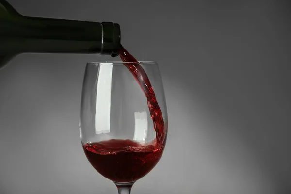 Verser Vin Rouge Dans Verre Sur Fond Gris — Photo