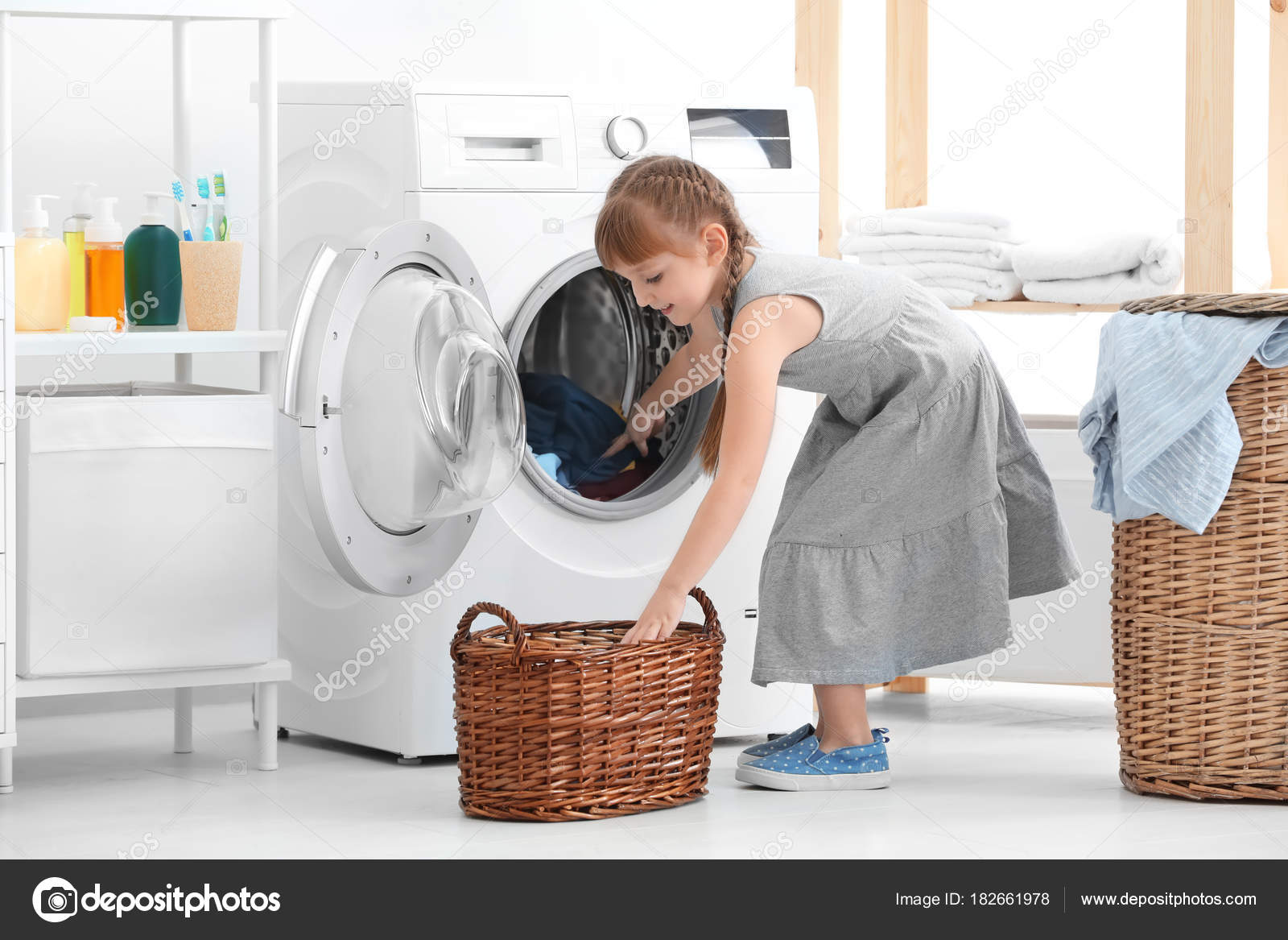 Cute Little Girl Doing Laundry Indoors Stock Photo by ©belchonock 182661978