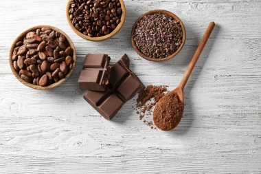 Beyaz ahşap arka planda kakao ürünleri içeren kompozisyon
