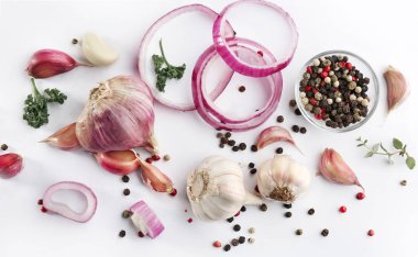 Taze sarımsak, soğan ve biber taneleri beyaz arka planda, üstten görünüm