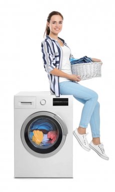 Çamaşır sepeti çamaşır makinesi beyaz arka plan üzerinde yakınındaki kadınla