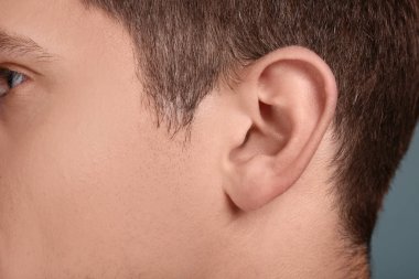 Genç adam, closeup kulak. İşitme sorunu