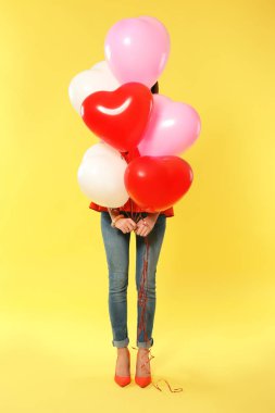 Renk arka plan üzerinde balon Sevgililer günü için kalp şeklinde olan romantik kadın