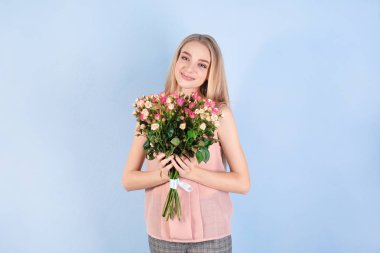 Renkli arka planda gül buketi olan güzel bir kadın.