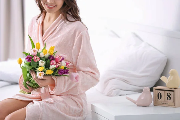 自宅のベッドにチューリップの花束の美女 — ストック写真