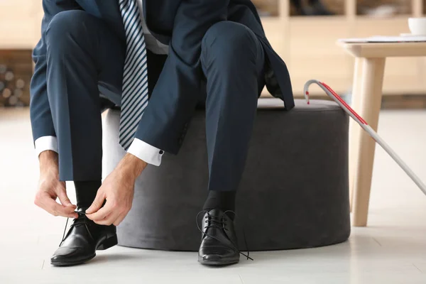 Young man trying on shoes in shop