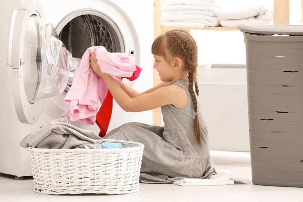 可爱的小女孩在室内洗衣服 — 图库照片