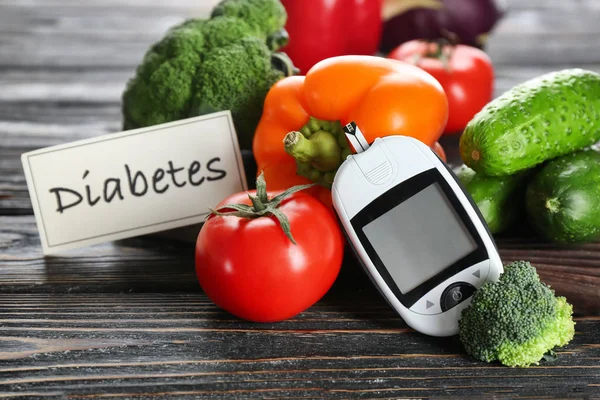 Digital glucometer and vegetables on table. Diabetes diet