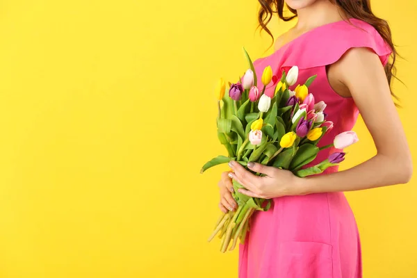 色の背景上チューリップの花束を持った美しい女性 — ストック写真