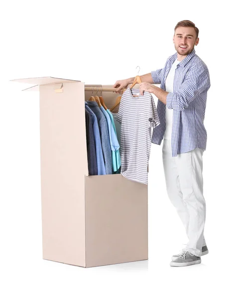 Hombre joven cerca de la caja de armario sobre fondo blanco — Foto de Stock