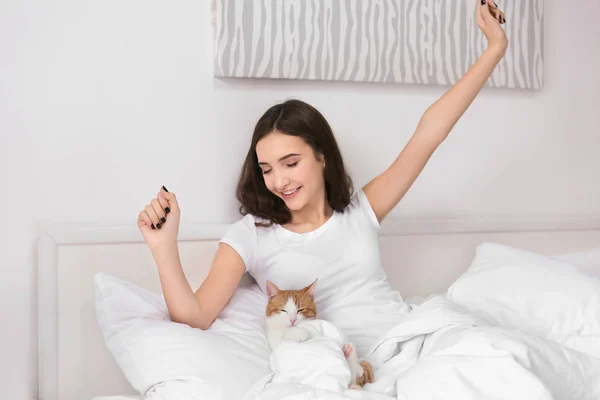 Mulher bonita com gato bonito na cama em casa — Fotografia de Stock