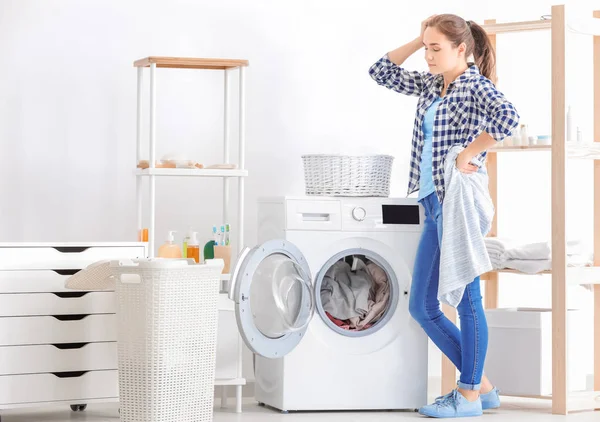 在家里洗衣服的年轻妇女 — 图库照片