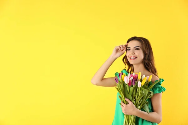 色の背景上チューリップの花束を持った美しい女性 — ストック写真